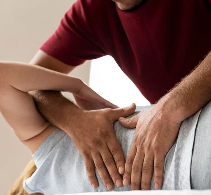 A man in a red shirt is giving a woman a massage