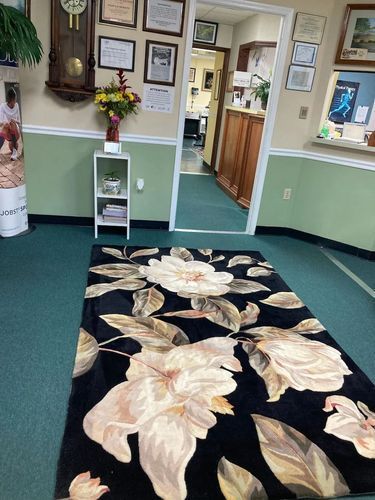 There is a rug with flowers on it in the middle of the room.