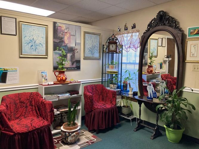 A waiting room with red chairs and a large mirror