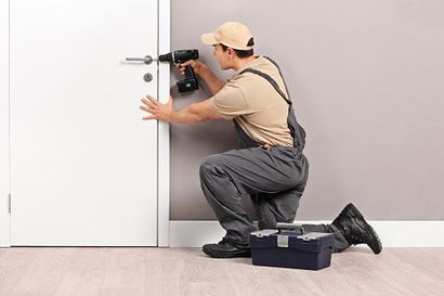 Locksmith Installing a Lock on a Door — locksmith in Philadelphia, PA