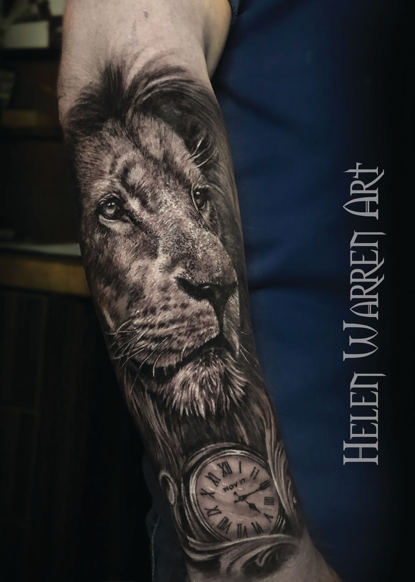 Lion portrait tattoo on arm, black and white, with pocket watch.