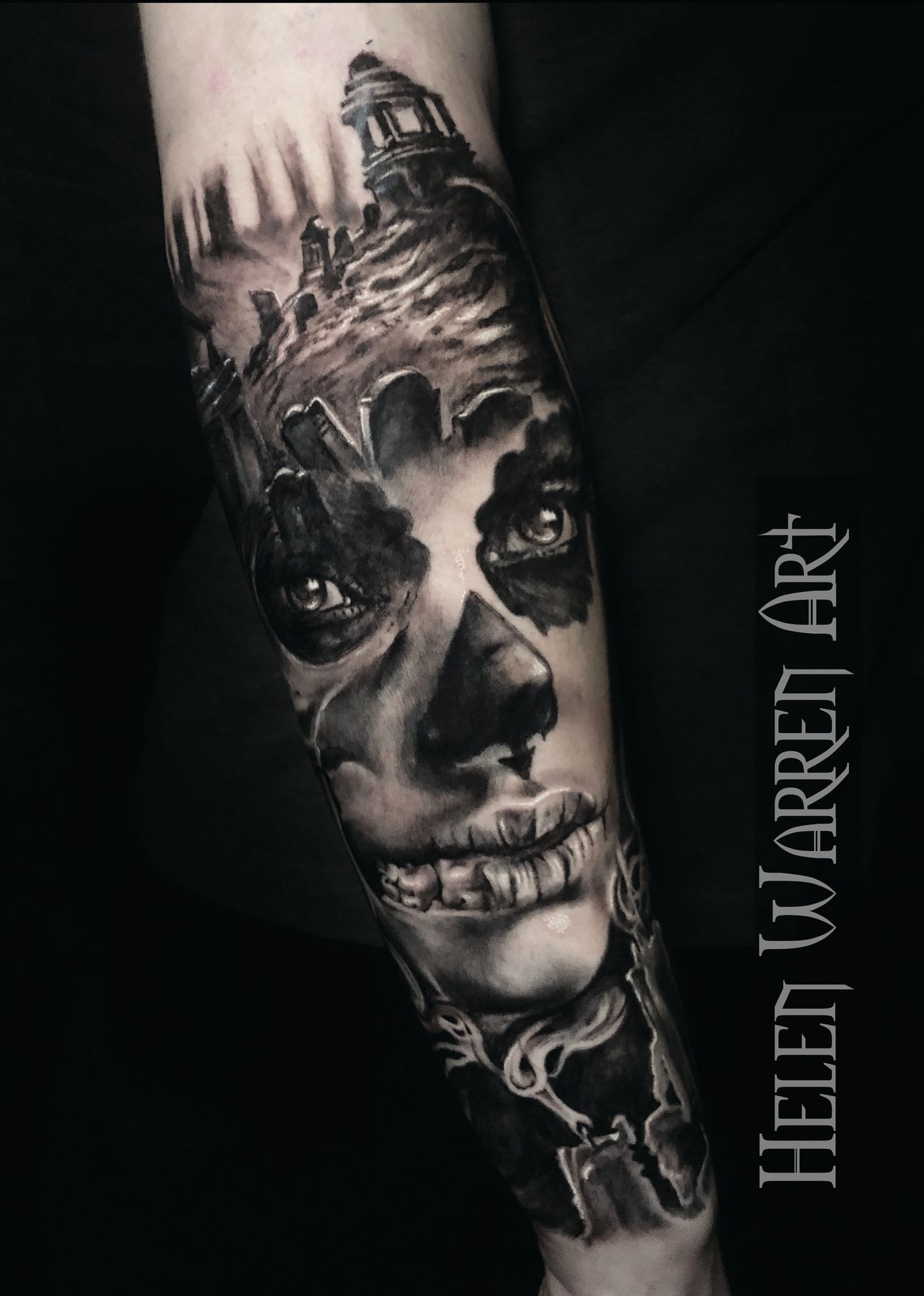 Tattoo of a skull woman with a lighthouse and keys. Black and gray shading.