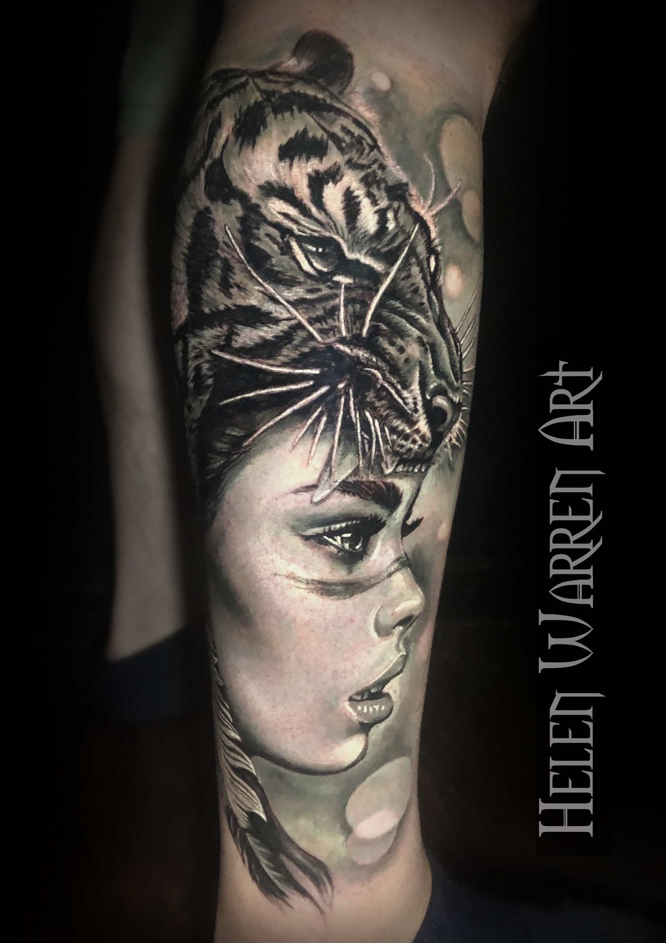 Black and white tattoo on leg of woman with tiger head overlay.