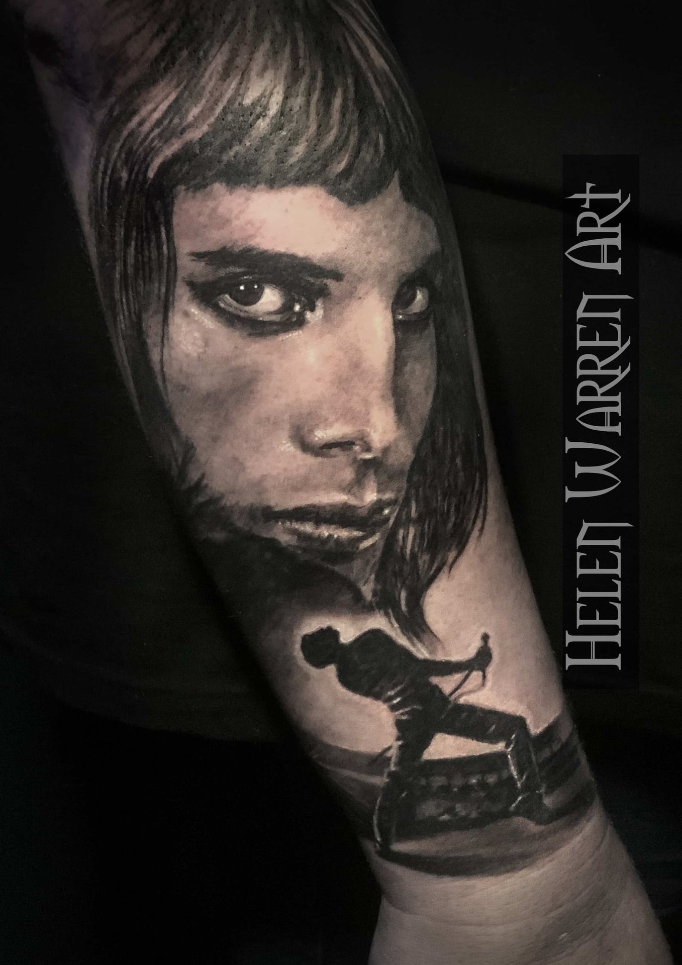 Tattoo of a person's face, a silhouette of a person performing on stage. Black and white.