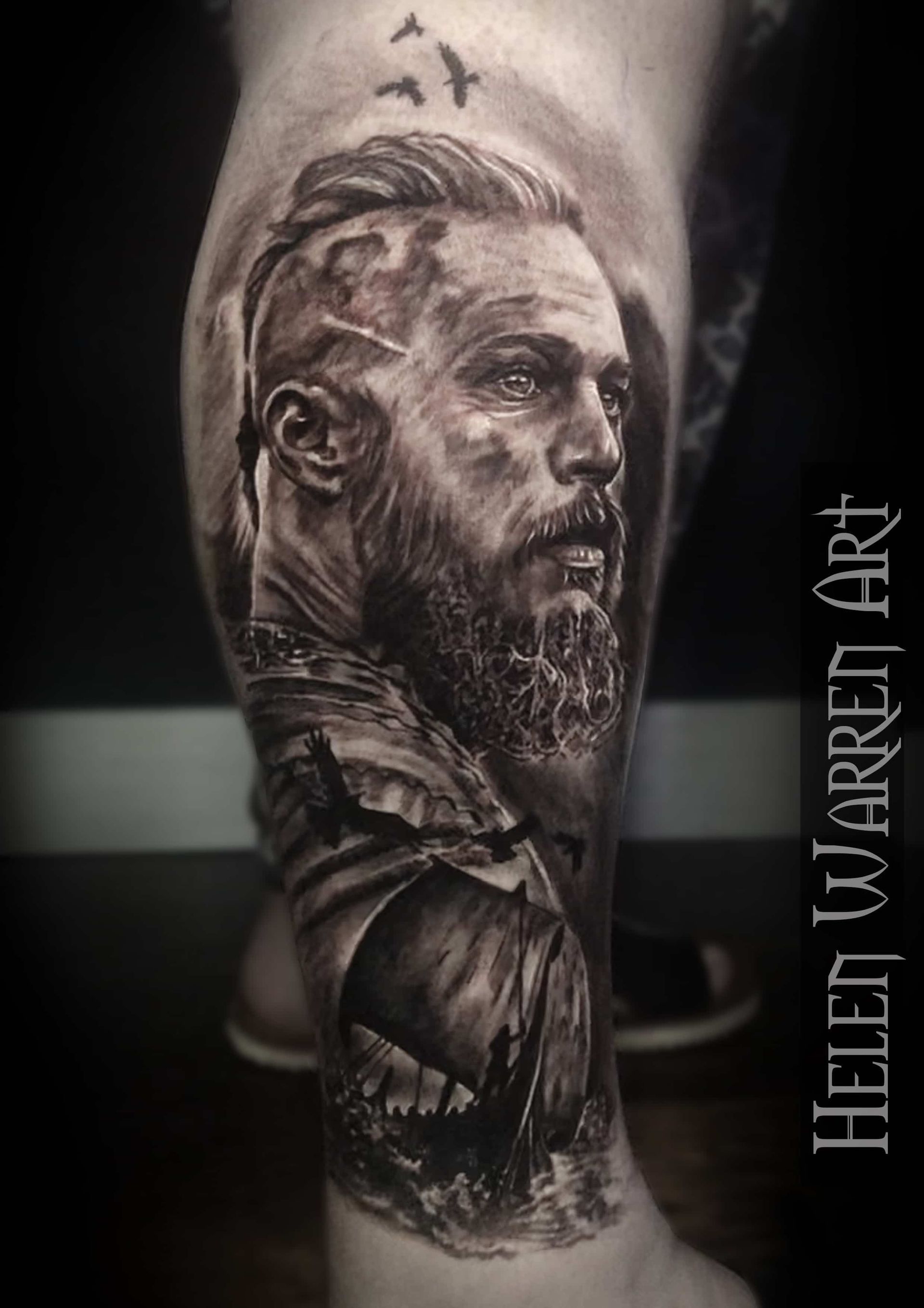 Tattoo of a bearded man with a ship. Black and white, detailed shading, birds flying in the background.