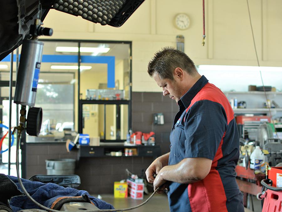 A man is working on a car in a garage