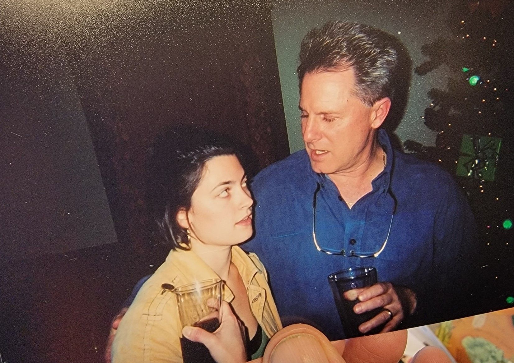 Woman in yellow jacket and man in blue shirt talking.