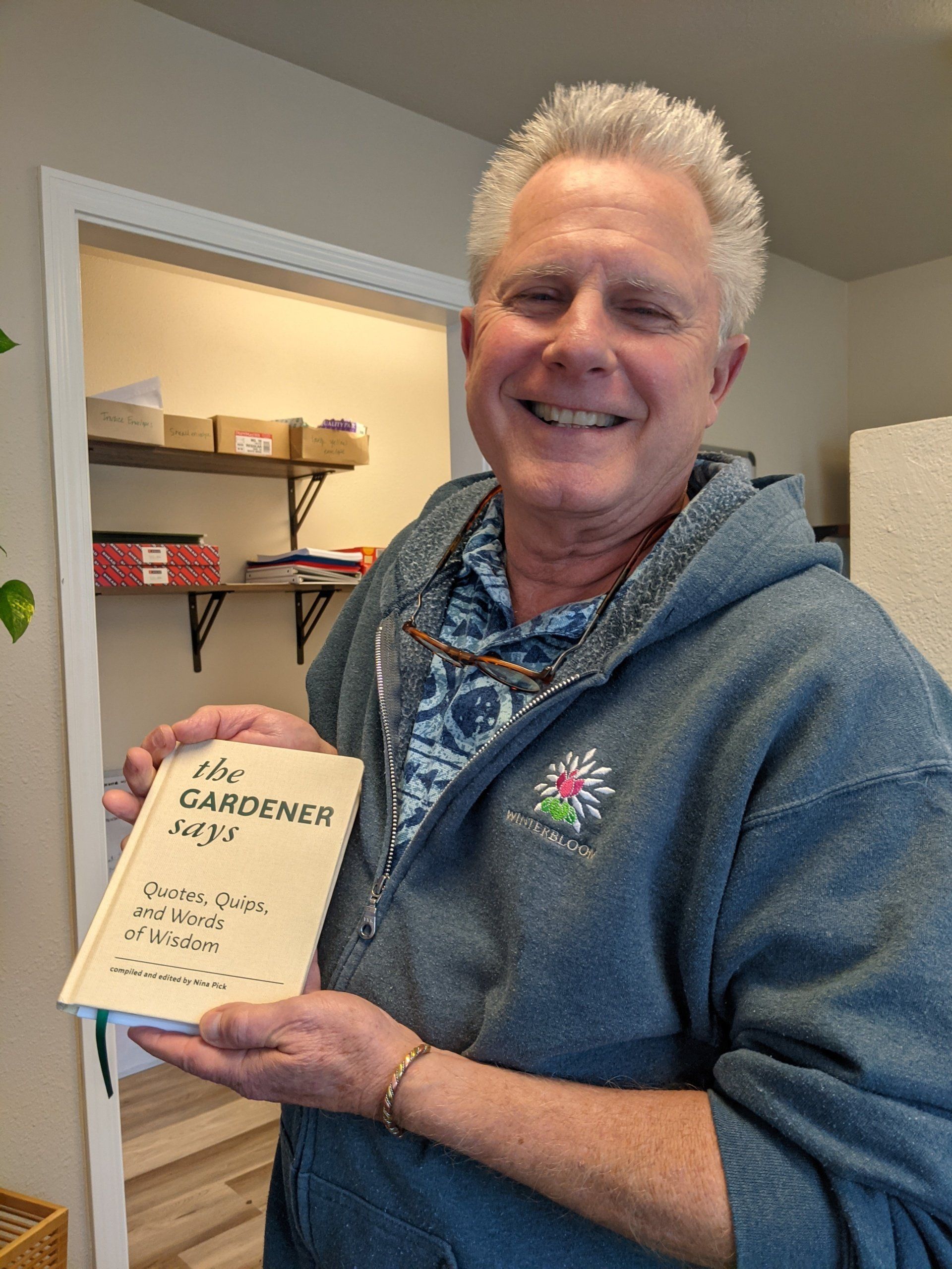 Man smiling, holding a book titled 