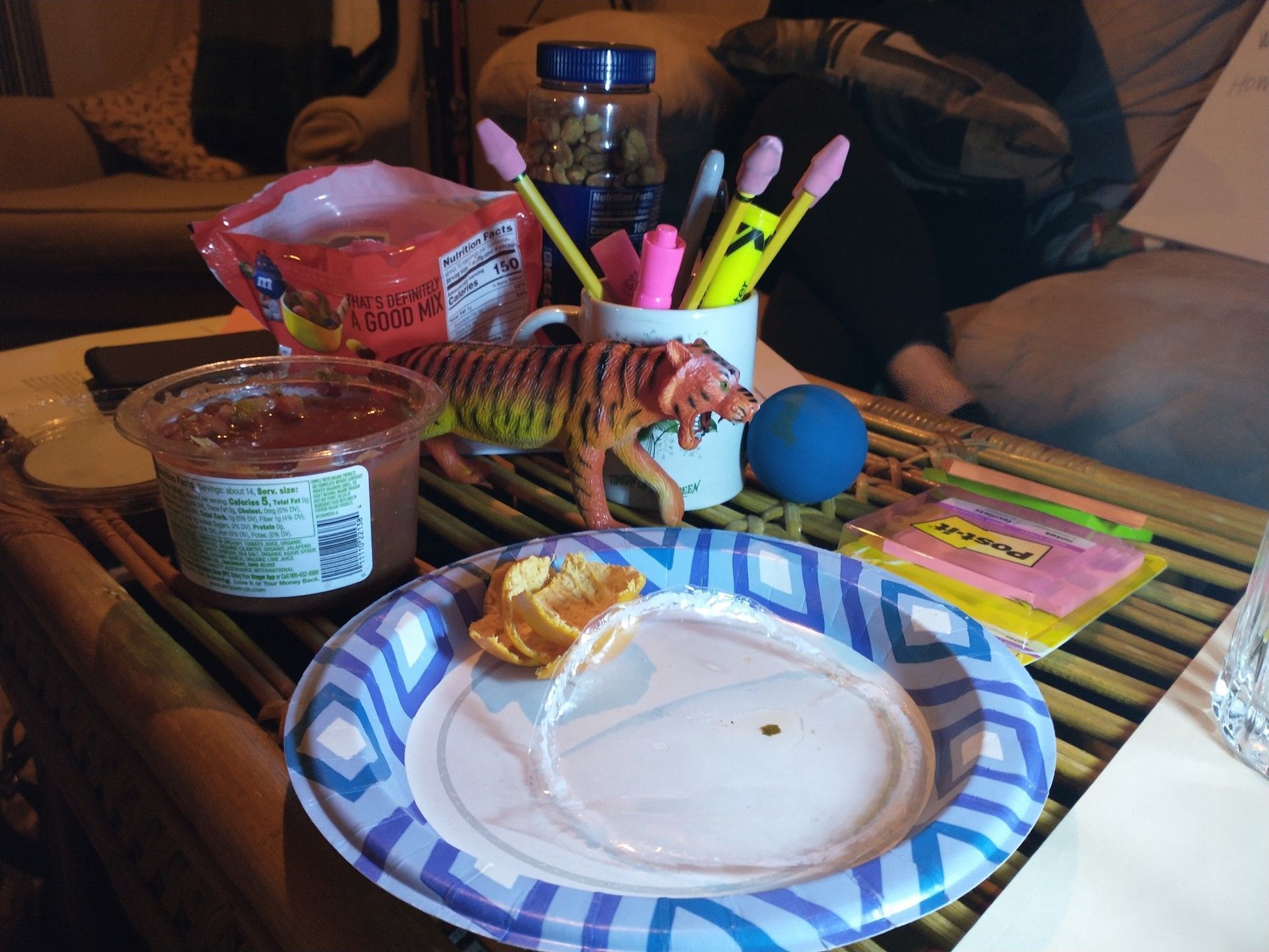 A still-life scene on a table includes food, a tiger figurine, and other objects, all lit by artificial light.