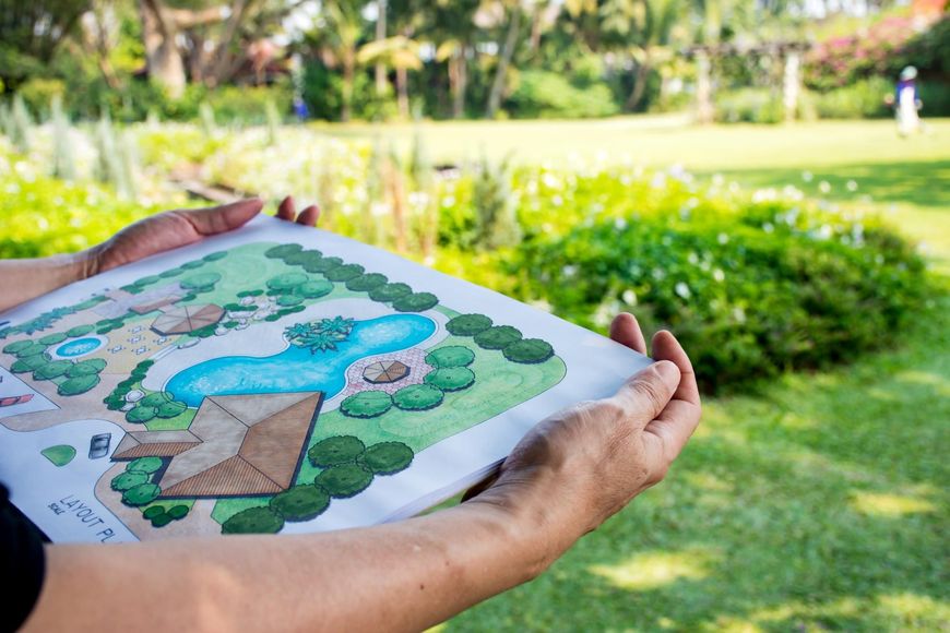 Hands holding a color landscape design plan.