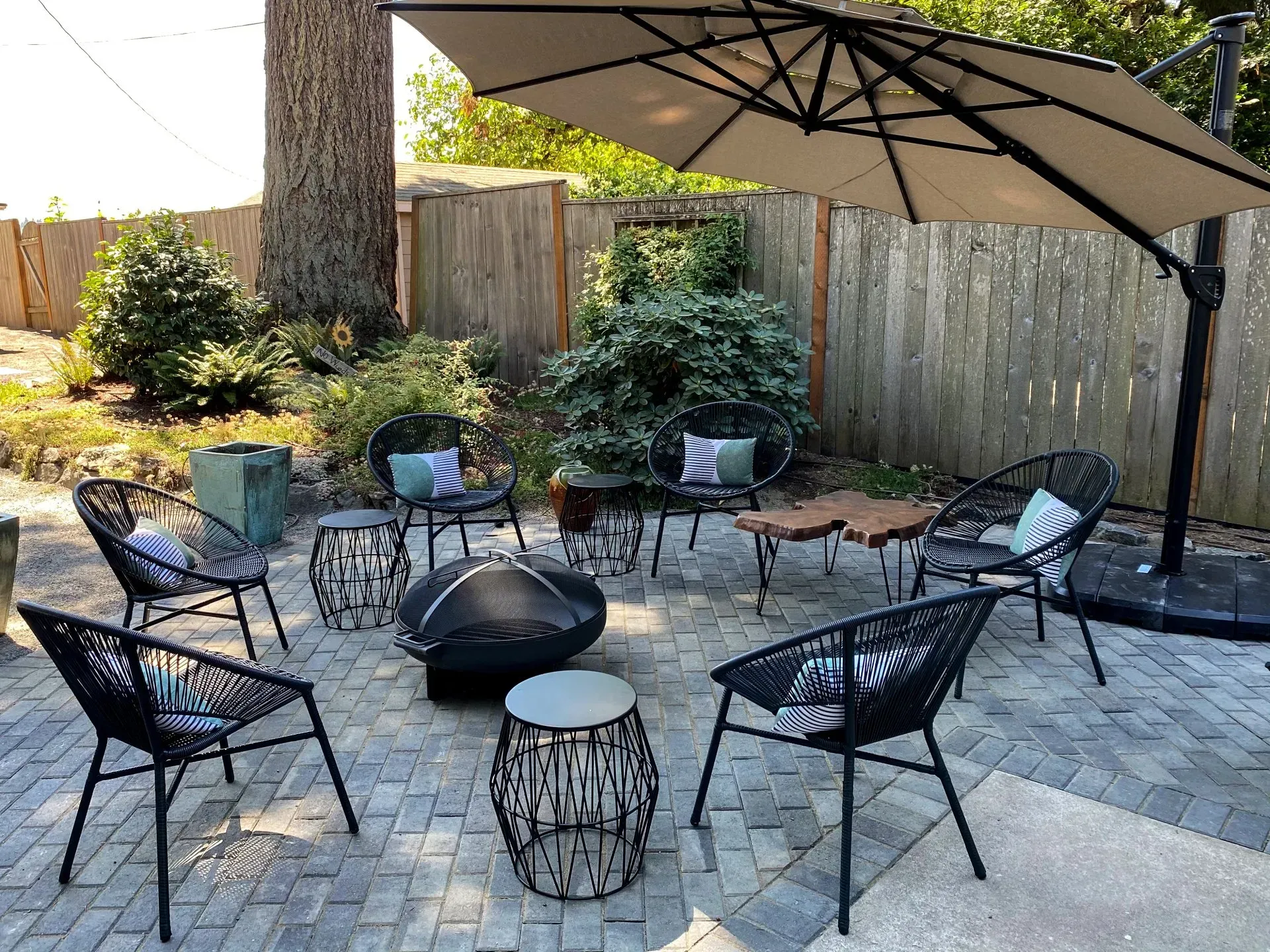 Patio seating area with black chairs, a fire pit.