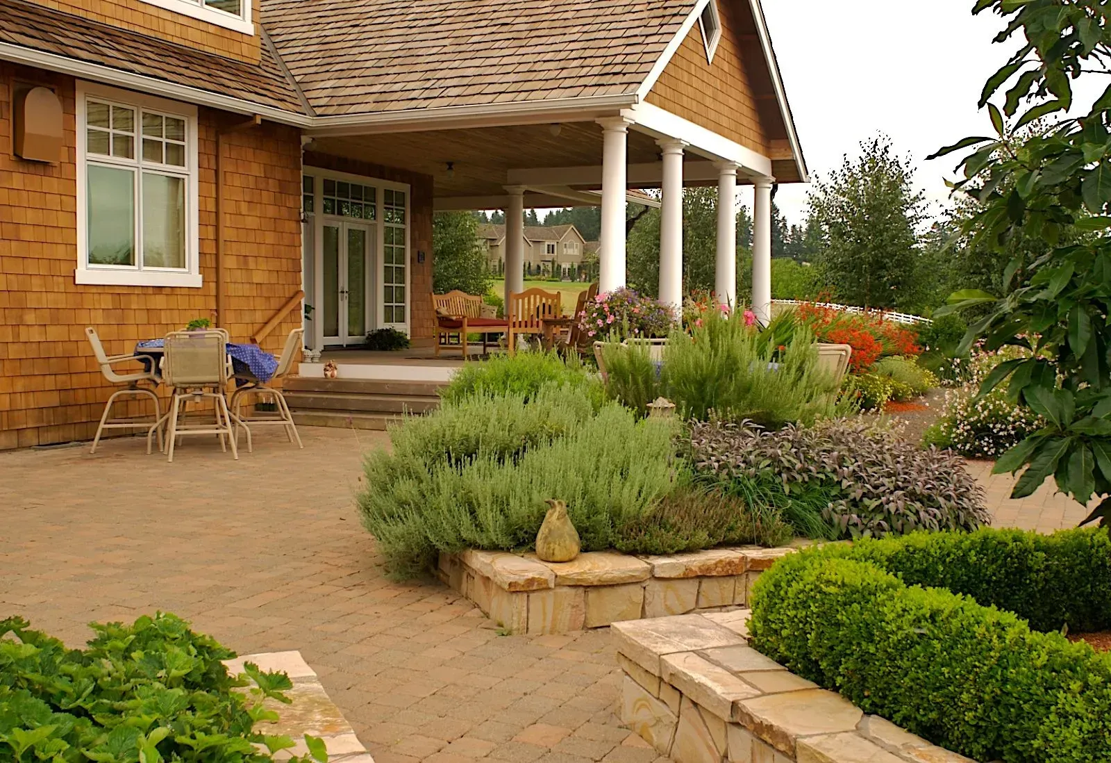 Patio garden with a house in the background.