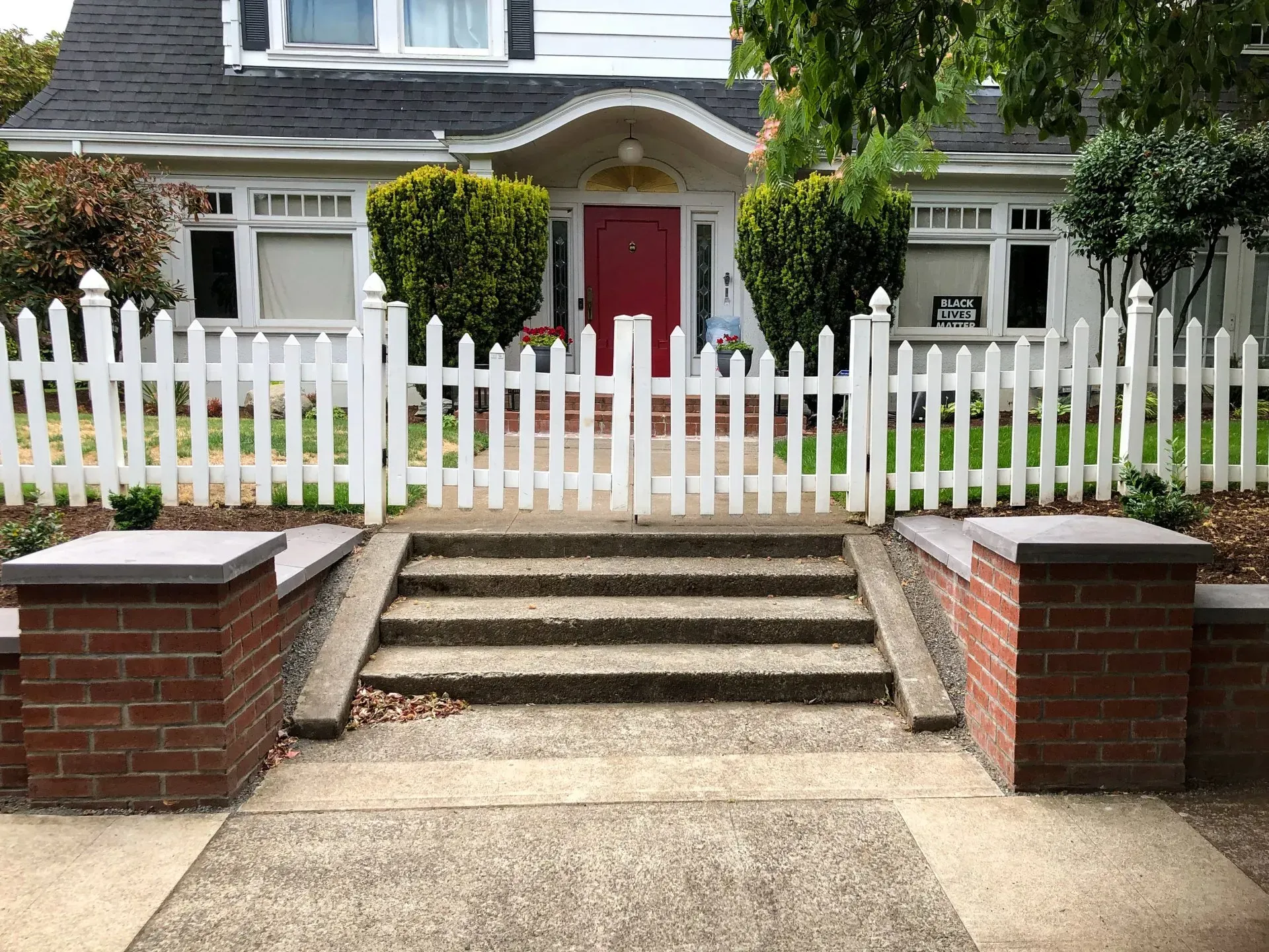 A two-story white house with a red front door. 