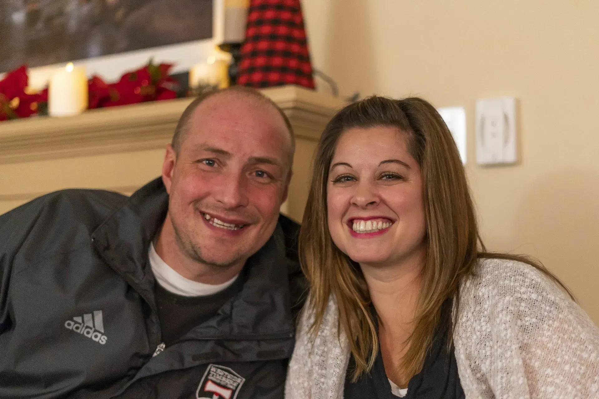 A man and woman smiling at the camera, close-up shot. 