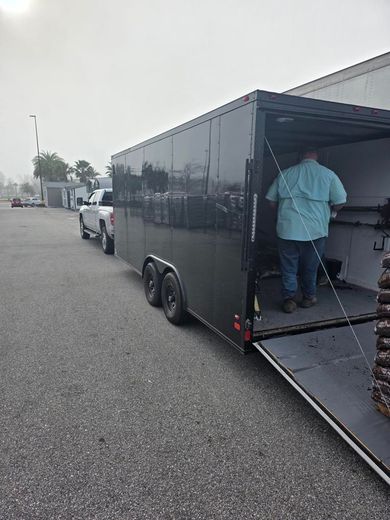 A man is getting out of a trailer in a parking lot.