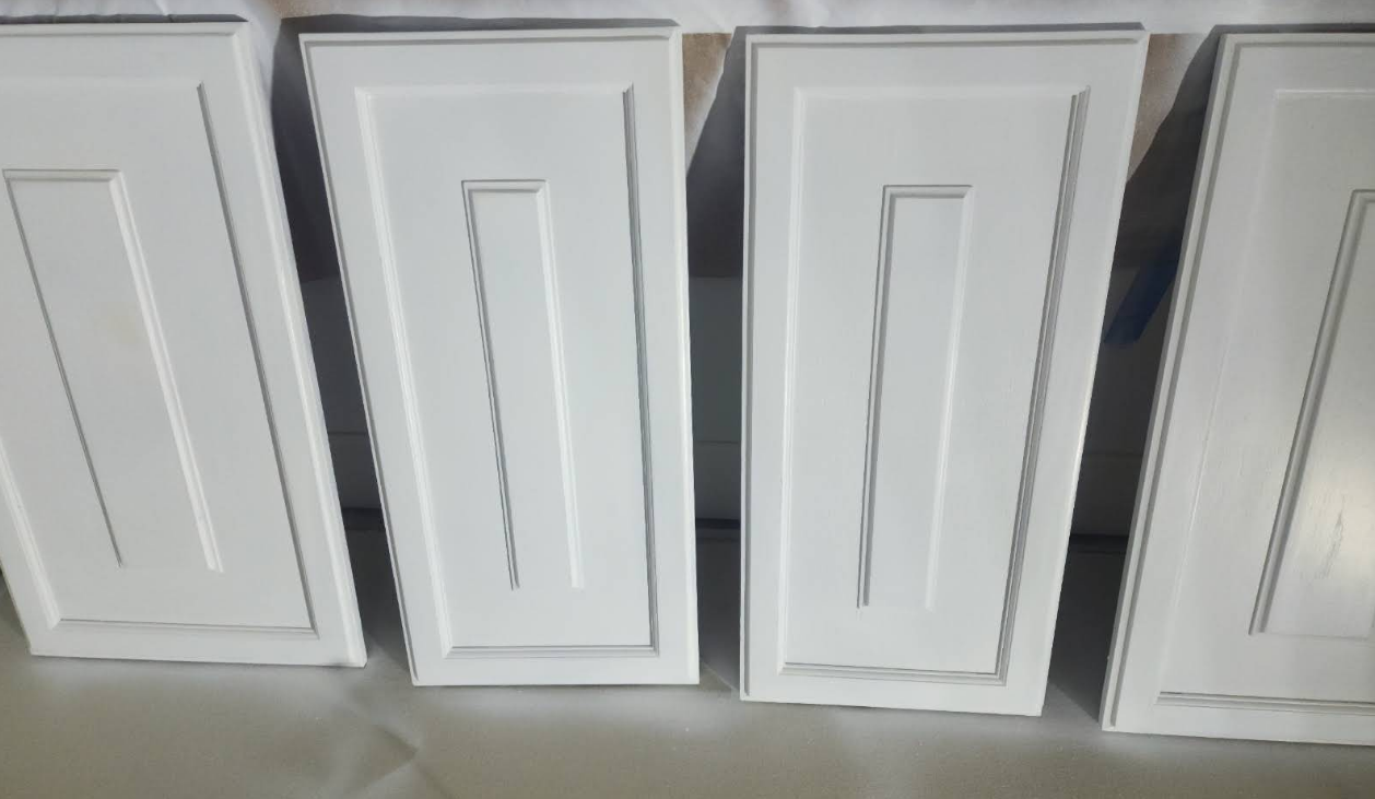 Four white cabinet doors with a recessed panel design.