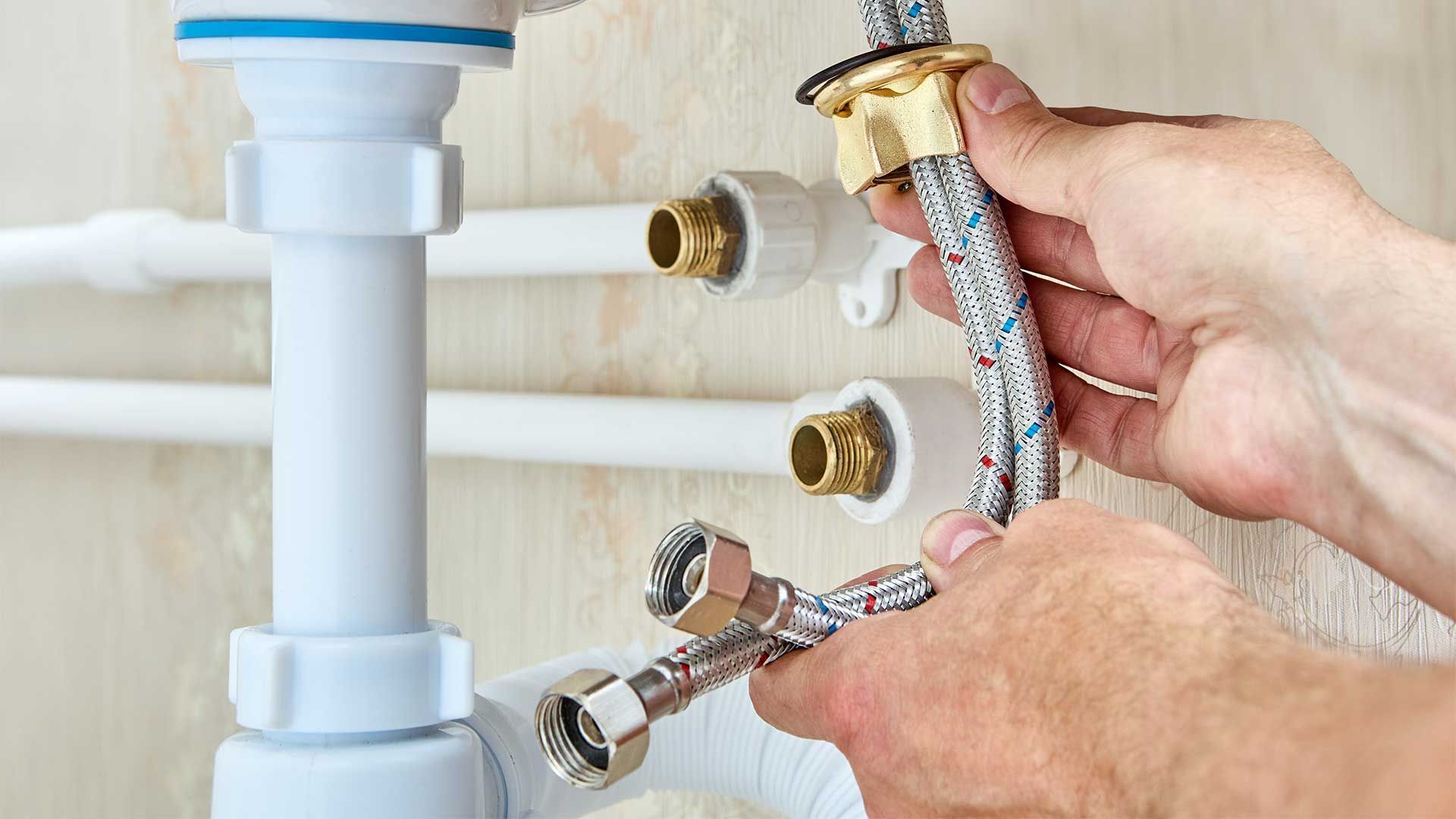 A person is fixing a sink with a hose.