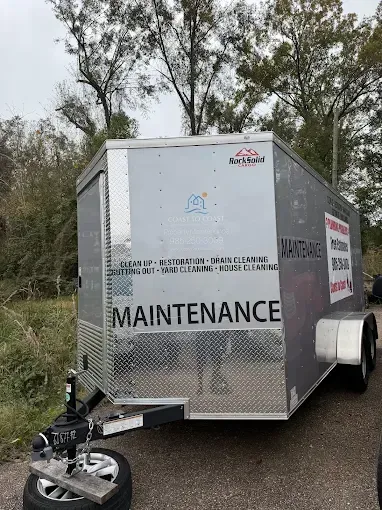 A silver, enclosed utility trailer parked outdoors, labeled with 