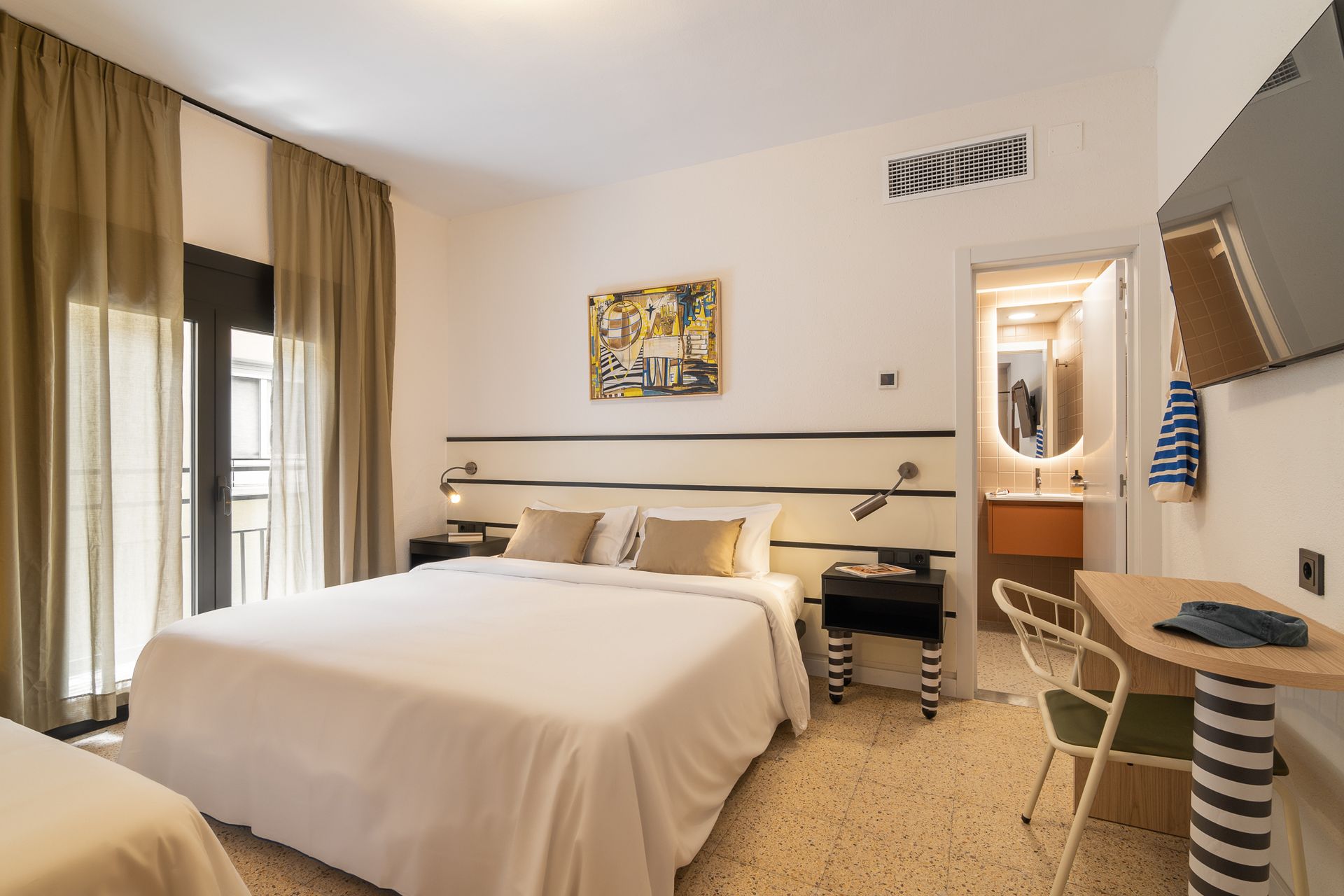 A hotel room with two beds , a desk and a television.