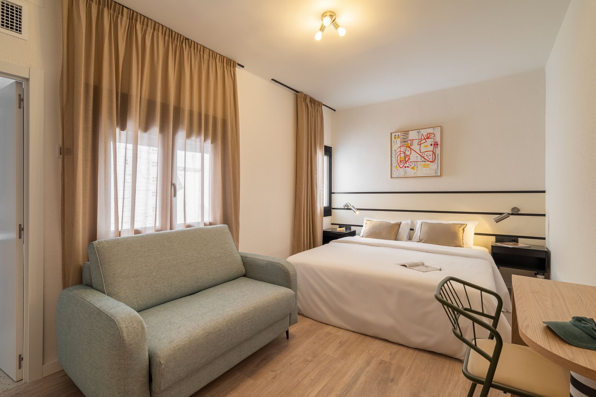 A hotel room with a couch and a bed