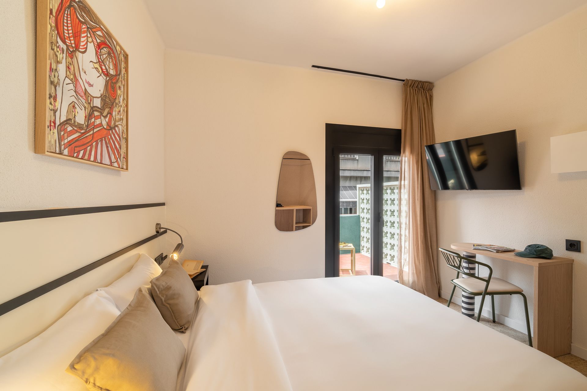 A hotel room with a bed , desk , chair and television.