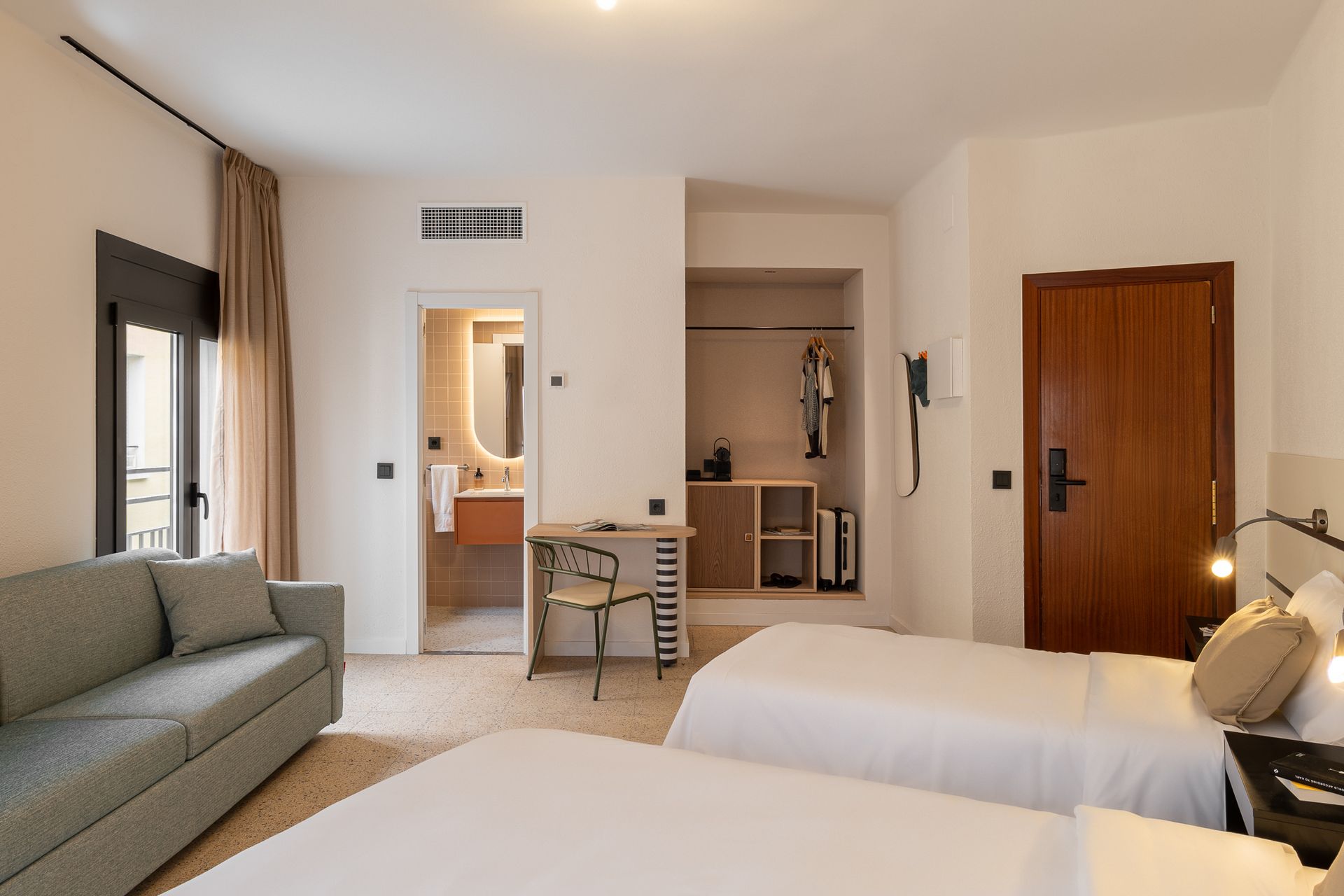 A hotel room with two beds and a couch