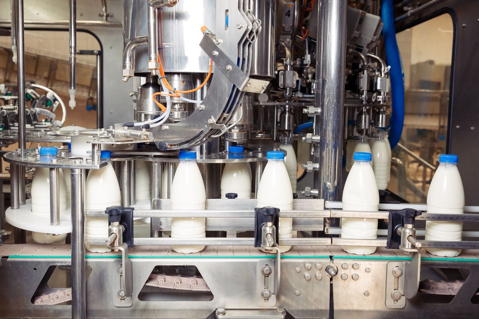 Equipment from dairy equipment suppliers, which fills milk into plastic bottles at a factory.