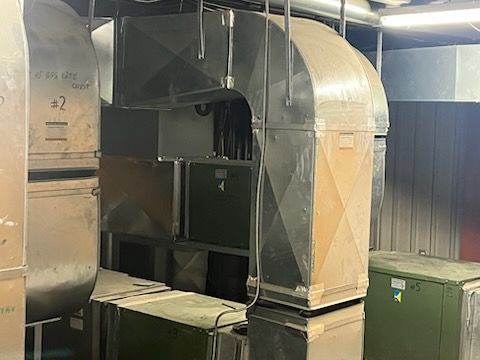 Un gros tuyau métallique est suspendu au plafond d'un bâtiment.