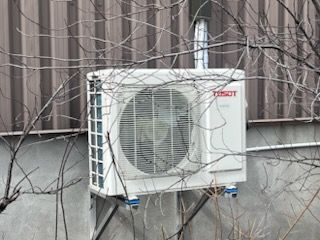 Un climatiseur Tissot est monté sur le côté d'un bâtiment.