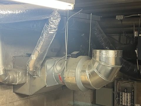 Un tuyau métallique est suspendu au plafond d'une pièce.