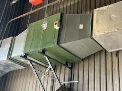 Une grande boîte verte est suspendue au plafond d'un bâtiment.