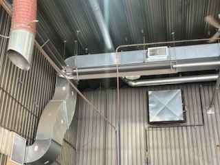 Il y a beaucoup de tuyaux suspendus au plafond d'un bâtiment.