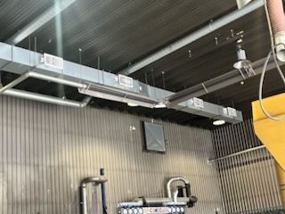 Une pièce avec beaucoup de tuyaux suspendus au plafond.