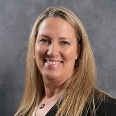 A woman with long blonde hair is smiling for the camera.