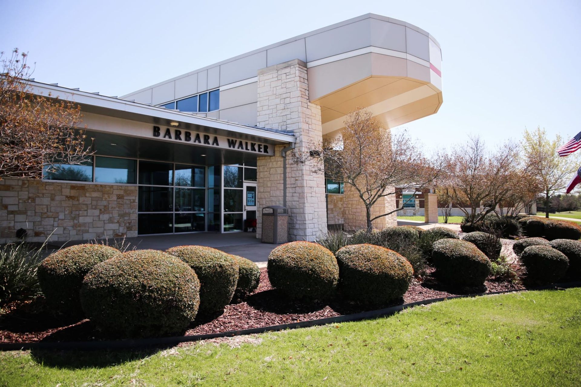A large building with a lot of bushes in front of it