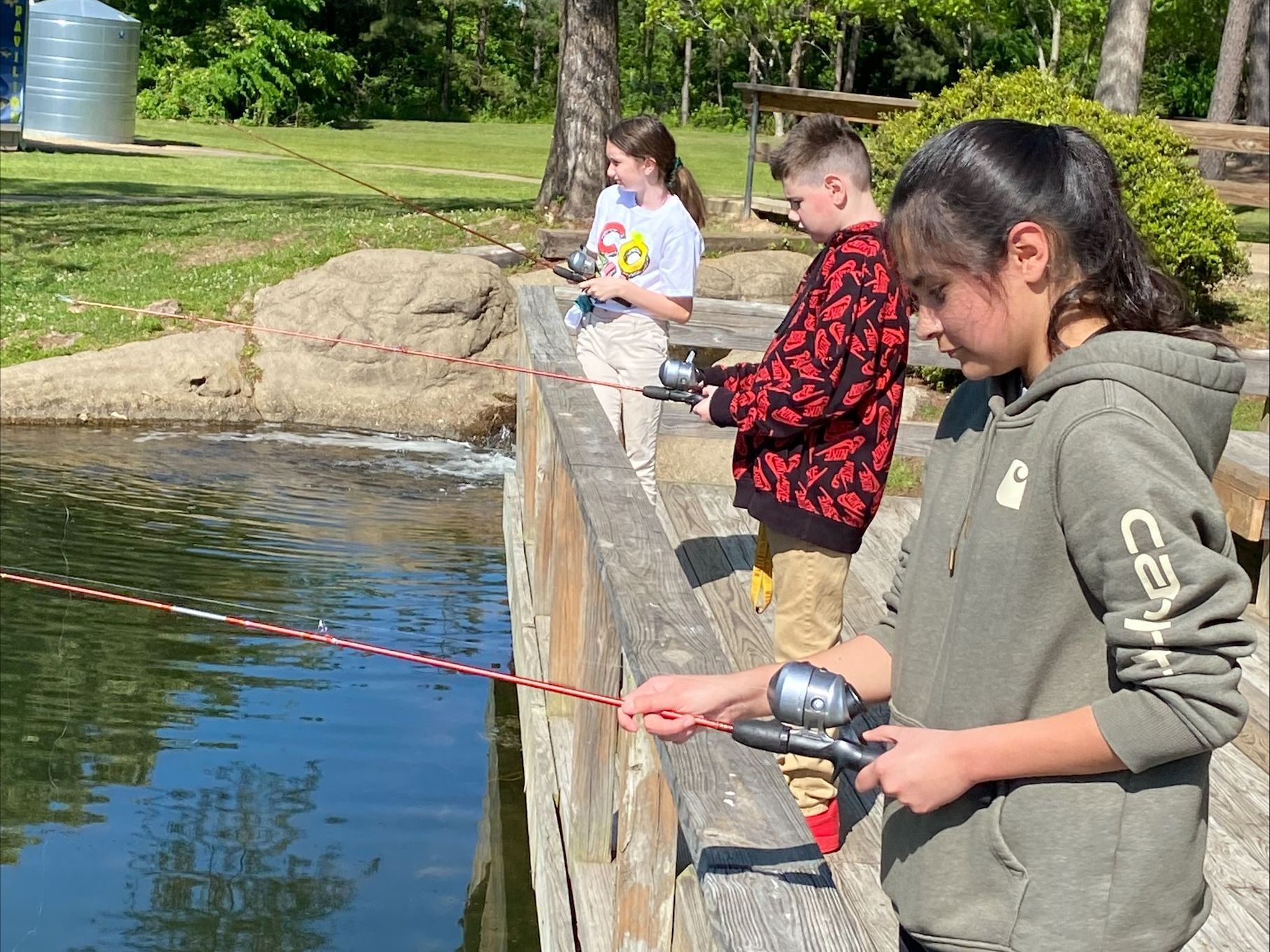 A group of children are fishing in a pond.