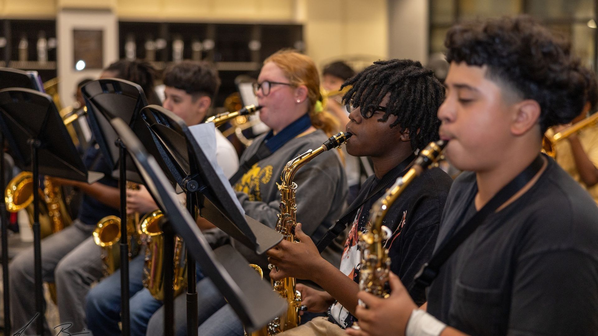 A group of young people are playing saxophones in a band.