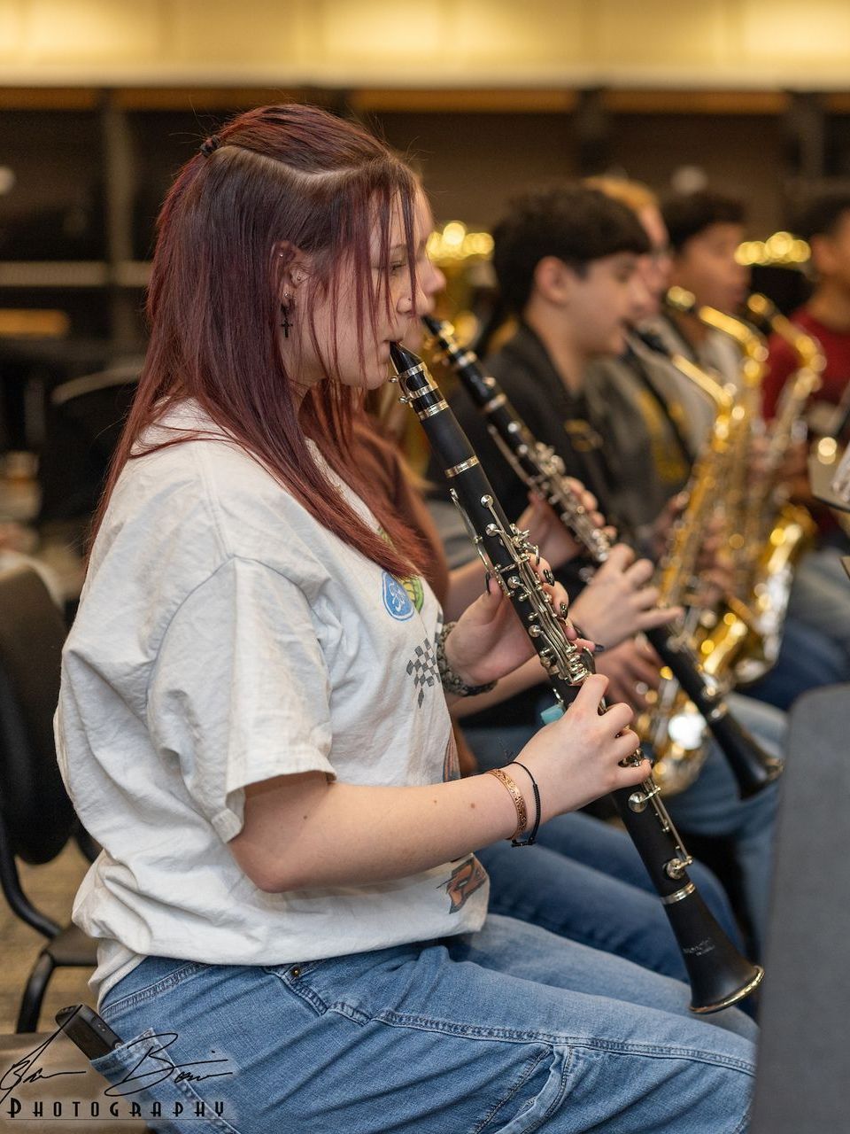 A woman is playing a clarinet in a band.