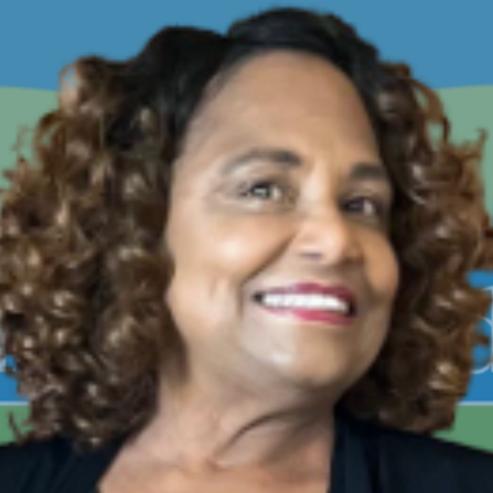 A woman with curly hair is smiling and wearing a black shirt