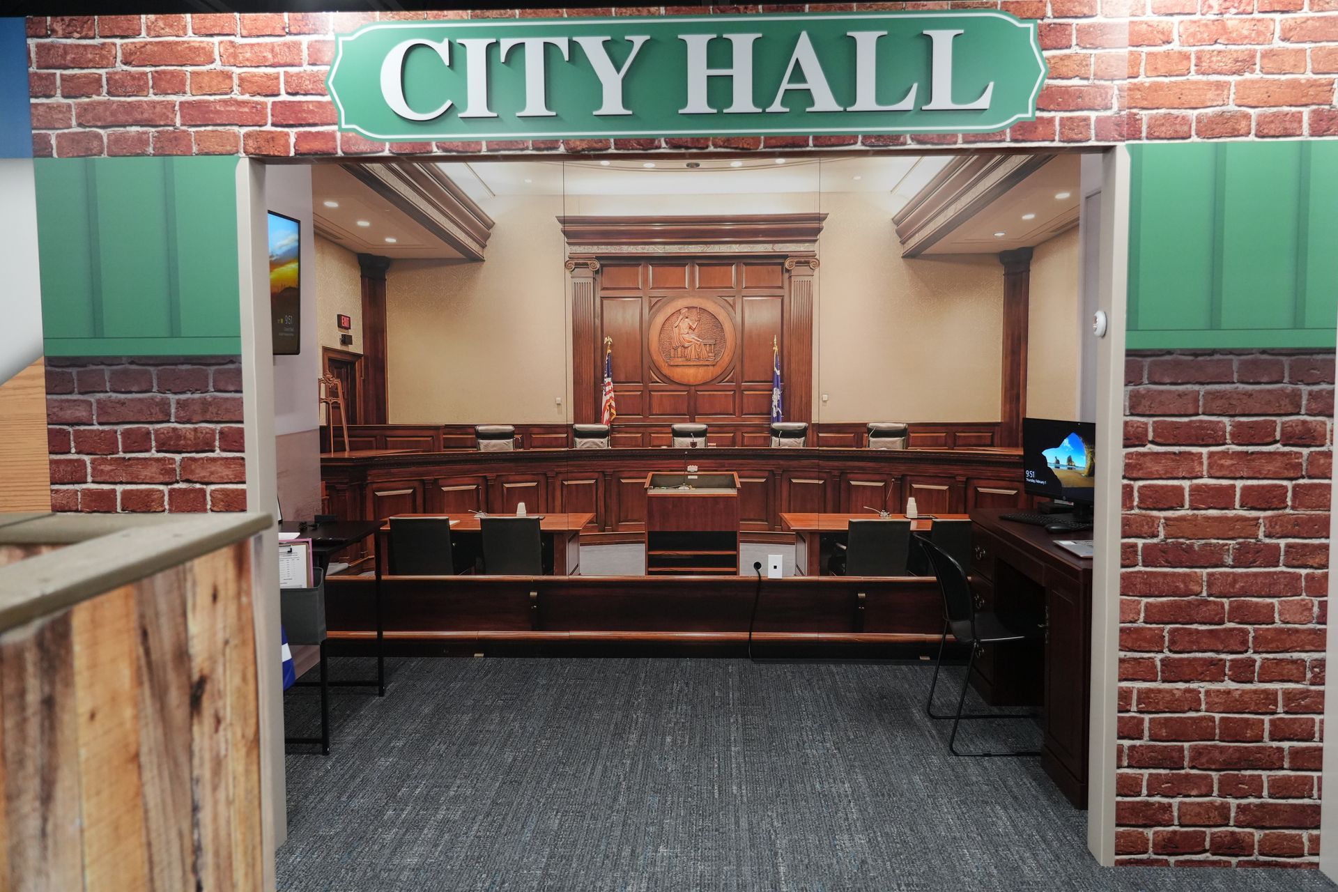 A city hall with a brick wall and a sign that says city hall
