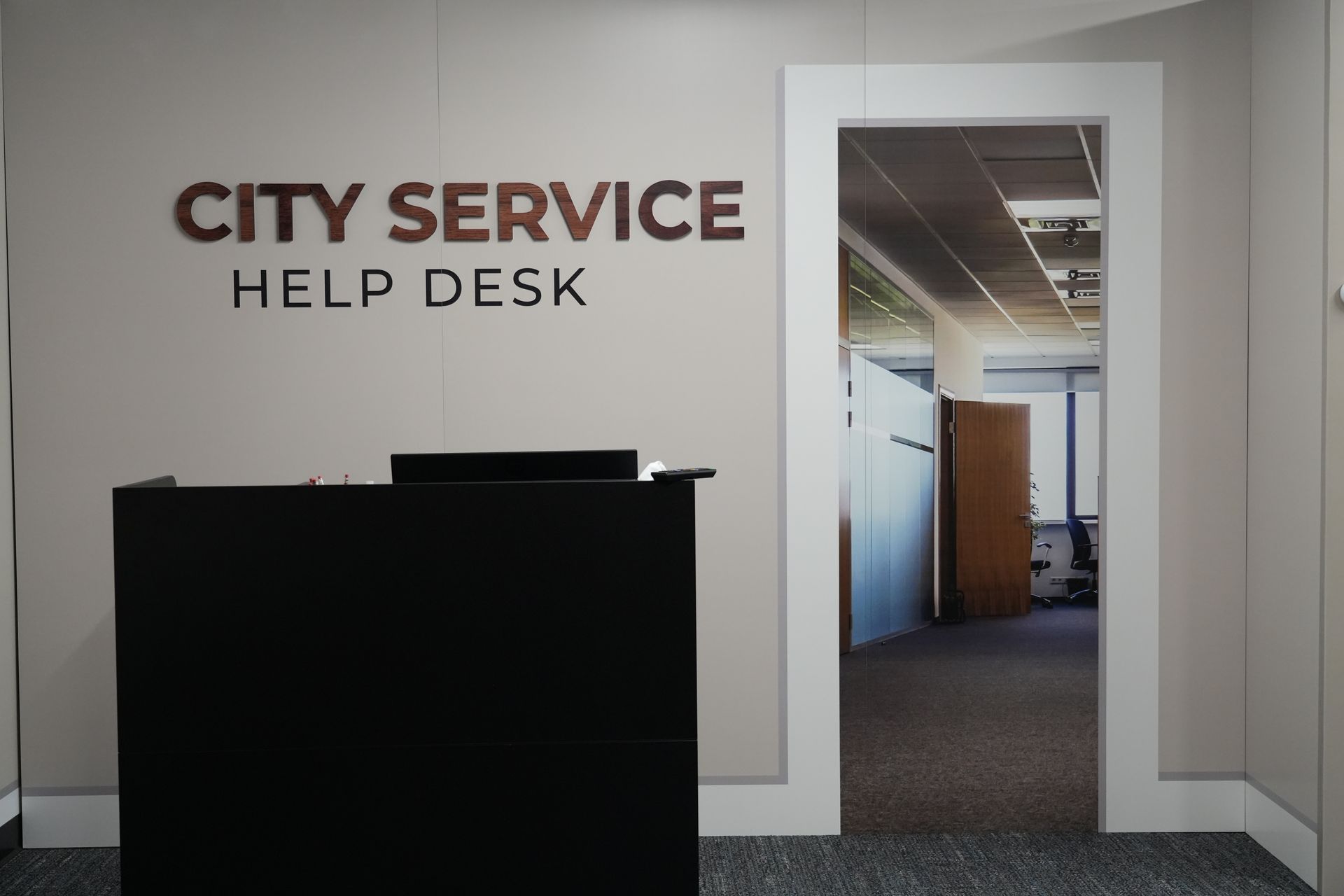 A city service help desk with a black desk