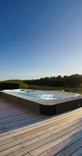 Un bain à remous est posé sur une terrasse en bois.