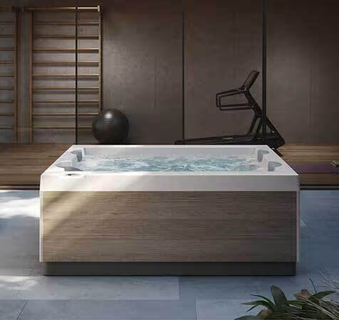 Un grand jacuzzi se trouve dans une pièce à côté d'un tapis roulant.