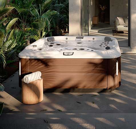 Un bain à remous est assis sur une terrasse à côté d'une serviette.