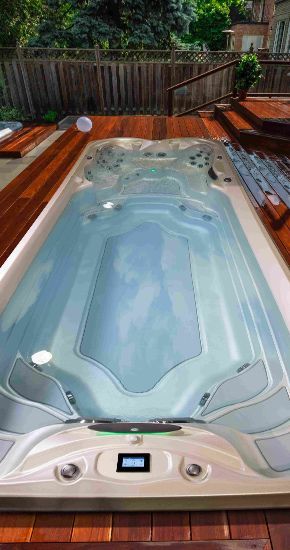 Une grande piscine est située au sommet d'une terrasse en bois.