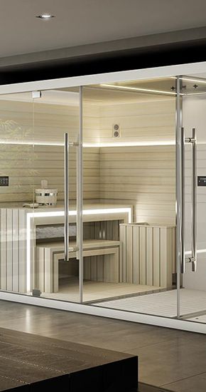 Sauna aux parois de verre, intérieur en bois, bancs et éclairage vif.