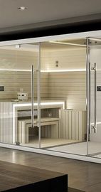 Sauna aux parois de verre, intérieur en bois, bancs et éclairage vif.