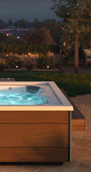 Un bain à remous est installé sur une terrasse dans une cour arrière.