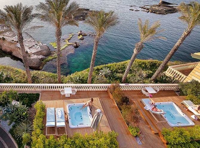 Une vue aérienne d'un complexe avec deux jacuzzis près de l'océan.