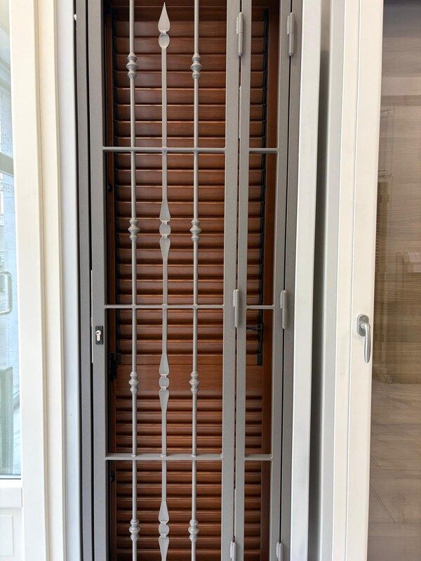 Porta di sicurezza in metallo sopra una porta di legno marrone.